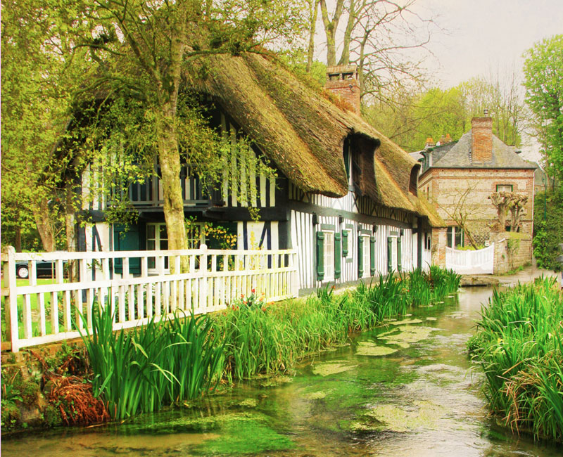 Thatched roof cottage along a river in Veules-les-Roses, Normand